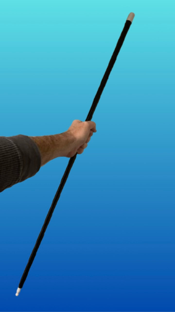 Hand holding the appearing black cane magic trick fully erect against a blue background