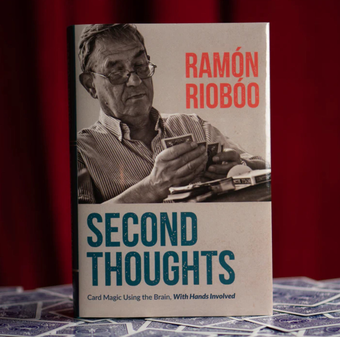 Hardcover book titled "Second Thoughts" by Ramón Rioboo, featuring a man holding playing cards.