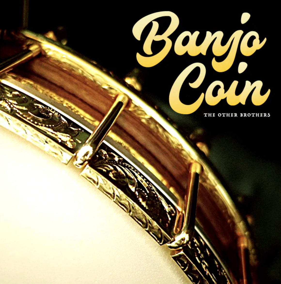 Close-up of a banjos rim and head with gold hardware. The words Banjo Coin appear in large, yellow script in the upper right, and The Other Brothers is written below in small, white text—highlighting magic tricks you can buy.