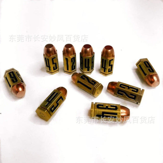 Gold-colored bullet casings, numbered 12, 45, and other numbers, scattered on a white surface.