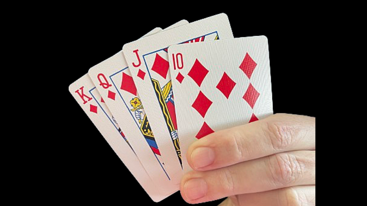 Hand holding four playing cards, showing a 10, Jack, Queen, and King of Diamonds.