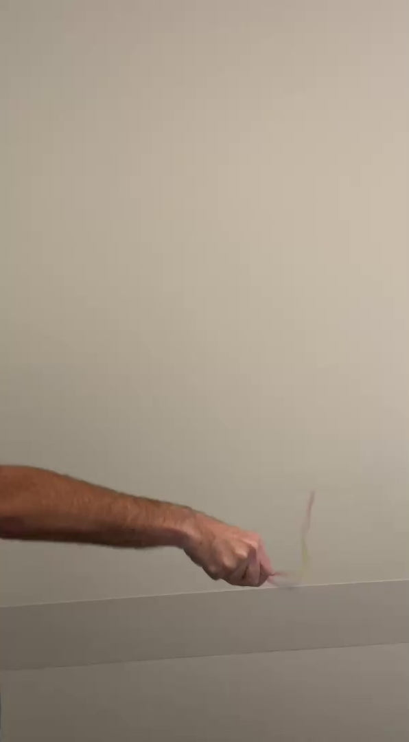 Hand holding a ribbon about to perform the appearing cane magic trick