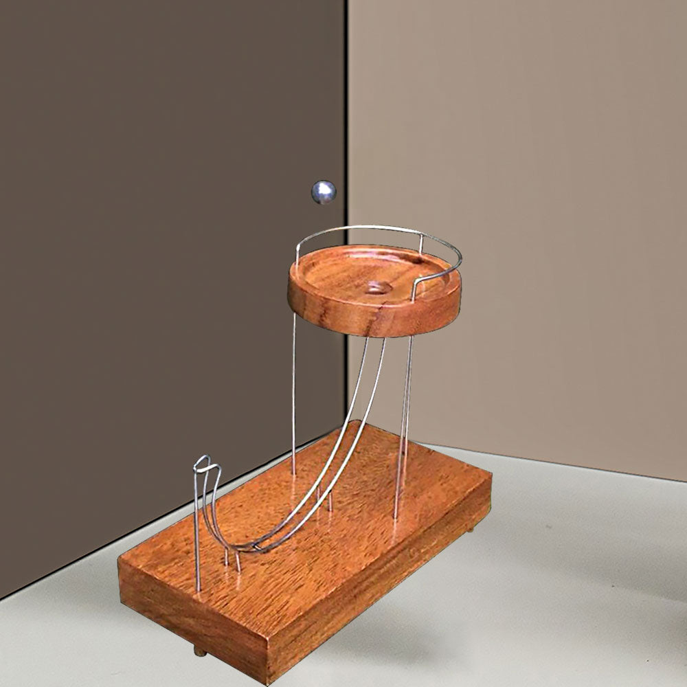 Wooden ball-launching toy with two metal ramps and a circular wooden platform.