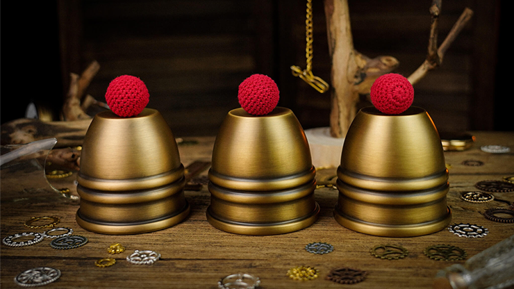 Three brass cups with three crochet red balls displayed on BBC an ornate background 